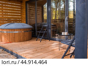 A-shaped frame house in Scandinavian style. The landscape. Quiet rest. The concept of glamping and chalet rentals. A wooden house with a veranda in nature around an autumn birch forest. Стоковое фото, фотограф Photojuli / Фотобанк Лори