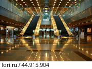 Escalators leading up and down in modern building interior. Стоковое AI-изображение, AI-художник Иван Рябоконь / Фотобанк Лори
