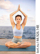 Yoga practice on embankment, female athlete fulfil carry out padmasana svastikasana, Siddhasana. Стоковое фото, фотограф Яков Филимонов / Фотобанк Лори