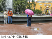 Heavy rain in Alexander Garden in center of St. Petersburg, at walls of Admiralty near fountain. Russia (2024 год). Редакционное фото, фотограф Валерия Попова / Фотобанк Лори