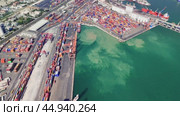 Cranes maneuvering shipping containers at a busy port efficiently load and unload cargo from large vessels, showcasing the dynamic nature of maritime logistics. Стоковое видео, видеограф ILIA GOROKHOV / Фотобанк Лори