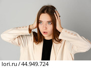 Young Woman Showing Surprise Expression on Gray Background. Стоковое фото, фотограф Сергей Толмачёв / Фотобанк Лори
