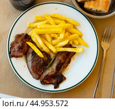 Few pieces of lamb liver are garnished with portion of French fries. Стоковое фото, фотограф Яков Филимонов / Фотобанк Лори
