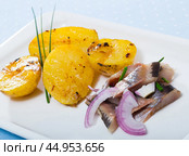 Slices of mild-cured herring with fried potatoes and onions served on plate. Стоковое фото, фотограф Яков Филимонов / Фотобанк Лори
