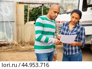 Female gardener discussing contract with representative of transport company. Стоковое фото, фотограф Яков Филимонов / Фотобанк Лори