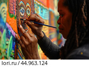 A woman artist creating a vibrant mural that pays homage to African culture and history. Стоковое AI-изображение, AI-художник Veniamin Kraskov / Фотобанк Лори