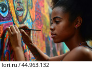 A woman artist creating a vibrant mural that pays homage to African culture and history. Стоковое AI-изображение, AI-художник Veniamin Kraskov / Фотобанк Лори
