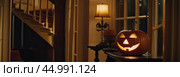 Halloween glowing decor in the cozy interior of the house made of pumpkins, garlands, Jack Latern, candles. Halloween party In the evening at dusk. AI generated. Стоковое AI-изображение, AI-художник Ольга Симонова / Фотобанк Лори