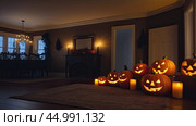 Halloween glowing decor in the cozy interior of the house made of pumpkins, garlands, Jack Latern, candles. Halloween party In the evening at dusk. AI generated. Стоковое AI-изображение, AI-художник Ольга Симонова / Фотобанк Лори