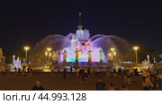 Москва, ВДНХ. Ночной вид на Фонтан Дружбы народов СССР. Цветовая подсветка. Гуляющие и отдыхающие люди. Редакционное видео, видеограф Сергей Никифоров-Гордеев / Фотобанк Лори