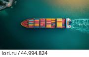 Aerial view of a large cargo ship navigating through turquoise waters during sunset. Стоковое AI-изображение, AI-художник Сергей Толмачёв / Фотобанк Лори