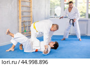 Elderly karate instructor demonstrating martial arts techniques in sparring with young fighter. Стоковое фото, фотограф Яков Филимонов / Фотобанк Лори