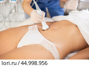 Female patient undergoing ultrasonic cavitation procedure on belly. Стоковое фото, фотограф Яков Филимонов / Фотобанк Лори