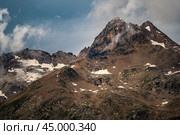 Gloomy atmospheric rocks, dark mountains covered with clouds and puffs of fog. Mountain peak of snow-capped mountains, beautiful panorama of mountains. dark high rocks. Стоковое фото, фотограф Павел Муравьев / Фотобанк Лори