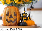 A vase of flowers, pumpkins and a scary castle with a witch on the background of a Scandi-style white kitchen interior. The concept of home and comfort. Autumn decor for Halloween. Стоковое фото, фотограф Photojuli / Фотобанк Лори