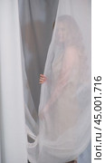 Vertical slow motion video of woman covered with white mesh fabric. A woman hides her face behind a veil cloth. Стоковое видео, видеограф Сергей Пристяжнюк (Serg Zastavkin) / Фотобанк Лори