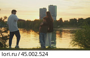 Parents jokingly pull the child towards them to embrace him. Стоковое видео, видеограф Strunov David / Фотобанк Лори
