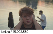 Two parents are shouting at each other and putting pressure on their child, who does not want to be involved in their arguments. Стоковое видео, видеограф Strunov David / Фотобанк Лори