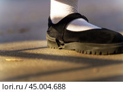 Stark contrast of elegance and wear, a white sock-clad foot nestles in a black shoe, showcasing a fractured sole an emblem of fragility beneath a facade of sophistication. Стоковое фото, фотограф Татьяна Степанищева / Фотобанк Лори