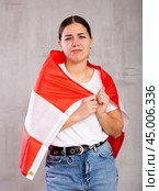 Sad young woman holding Austria flag against unicoloured background. Стоковое фото, фотограф Яков Филимонов / Фотобанк Лори