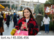 Girl with paper cup of warm drink walking at Christmas market. Стоковое фото, фотограф Яков Филимонов / Фотобанк Лори