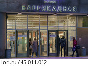 Moscow, Russia - October 14, 2019: Cityscape in night. Colorful entrance of metro station is full of people. Lifestyles of big city. Transl. "Metro named after V. Lenin, Barrikadnaya station." Редакционное фото, фотограф YuryKara / Фотобанк Лори