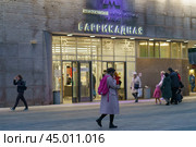Moscow, Russia - October 14, 2019: Cityscape in night. Colorful entrance of metro station is full of people. Lifestyles of big city. Transl. "Metro named after V. Lenin, Barrikadnaya station." Редакционное фото, фотограф YuryKara / Фотобанк Лори