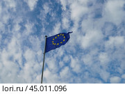 Flag of Europe (blue background and twelve five -pointed yellow stars). Flags blowing on the wind in a sunny summer day. Flags against blue sky background. (2019 год). Стоковое фото, фотограф YuryKara / Фотобанк Лори