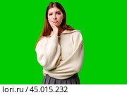 Young Woman Looking Bored and Disinterested Against Green Background. Стоковое фото, фотограф Сергей Толмачёв / Фотобанк Лори