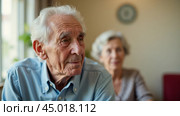 Senior man with advanced cognitive decline sitting in chair, appearing disoriented and confused, unable to recognize familiar objects, feeling lonely and depressed, showing signs of dementia. Стоковое AI-изображение, AI-художник Павел Муравьев / Фотобанк Лори