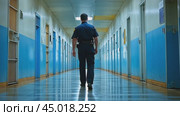Correctional officer walking down jail corridor past cells. Стоковое AI-видео, аниматор Юрий Поздников / Фотобанк Лори
