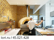 Chef Baking Pizza in a Traditional Wood-Fired Oven at an Italian Restaurant. Стоковое фото, фотограф Сергей Толмачёв / Фотобанк Лори