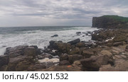 A rugged rocky shore covered in foamy waves. Суровый каменистый берег, которые накрывают пенные волны. Стоковое видео, видеограф Валерий Тесаков / Фотобанк Лори