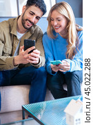 Happy man and woman have fun browsing the internet on a smartphone.Vertical. Стоковое фото, фотограф Raquel Corcoles Mendez / Фотобанк Лори