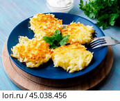 hashed browned potatoes on blue wooden background, side view, close up. Стоковое фото, фотограф Natalia Gdovskaia / Фотобанк Лори