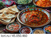 Moroccan cuisine served in colorful tagine on rustic table setting. Стоковое AI-изображение, AI-художник Иван Рябоконь / Фотобанк Лори