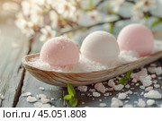 Bath bombs on rustic wooden plank with blossoms. Стоковое AI-изображение, AI-художник Иван Рябоконь / Фотобанк Лори