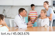 Family physician consults girl child with sore throat from large family at home. Стоковое фото, фотограф Яков Филимонов / Фотобанк Лори