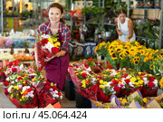 Middle-aged woman holding bouquet of flowers in large plants market. Стоковое фото, фотограф Яков Филимонов / Фотобанк Лори