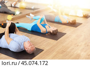 Elderly man doing glutes stretching exercises at training in gym. Стоковое фото, фотограф Яков Филимонов / Фотобанк Лори