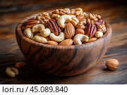 Вкусные орешки в красивой деревянной миске. Стоковое AI-изображение, AI-художник Щеголева Ольга / Фотобанк Лори