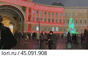 SAINT PETERSBURG, RUSSIA-December 25, 2023: Video of people walking on Palace Square and watching colorful show projected onto General Staff building in Christmas and New Year winter holidays. Редакционное видео, видеограф Виктория Катьянова / Фотобанк Лори