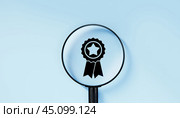 Magnifying glass focuses on quality warranty icon, quality assurance, ISO certification, and standardization concept. Compliance to regulations. blue background. Стоковое фото, фотограф Павел Муравьев / Фотобанк Лори