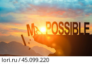 Businessman push impossible wording to possible wording on top of mountain with bright sunset sky. Positive mindset concept. Стоковое фото, фотограф Павел Муравьев / Фотобанк Лори