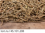 Frame made of new silver screws lying on a wooden surface. Стоковое фото, фотограф Александр Собко / Фотобанк Лори