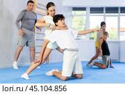 Boy and girl train to perform defense of strangling opponent, while learning self-defense. Стоковое фото, фотограф Яков Филимонов / Фотобанк Лори