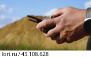 a builder with a quadcopter or a surveyor controls a quadcopter. Стоковое видео, видеограф Igor Skripachev / Фотобанк Лори
