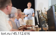 Young female IT teacher conducts lesson teaching elderly people on computer in nursing home. Стоковое видео, видеограф Яков Филимонов / Фотобанк Лори
