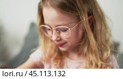 A little girl wears a smartwatch on her wrist and controls the functions by tapping on the screen. Стоковое видео, видеограф Енваев Андрей / Фотобанк Лори