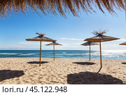 Морской пейзаж с тростниковыми зонтиками на песчаном пляже.  reed beach umbrella against the blue sea. Стоковое фото, фотограф Лариса Гордеева / Фотобанк Лори